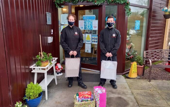 Two fire bridge officers with Christmas gifts