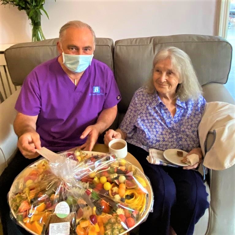carer and resident with fresh fruit thank you gift