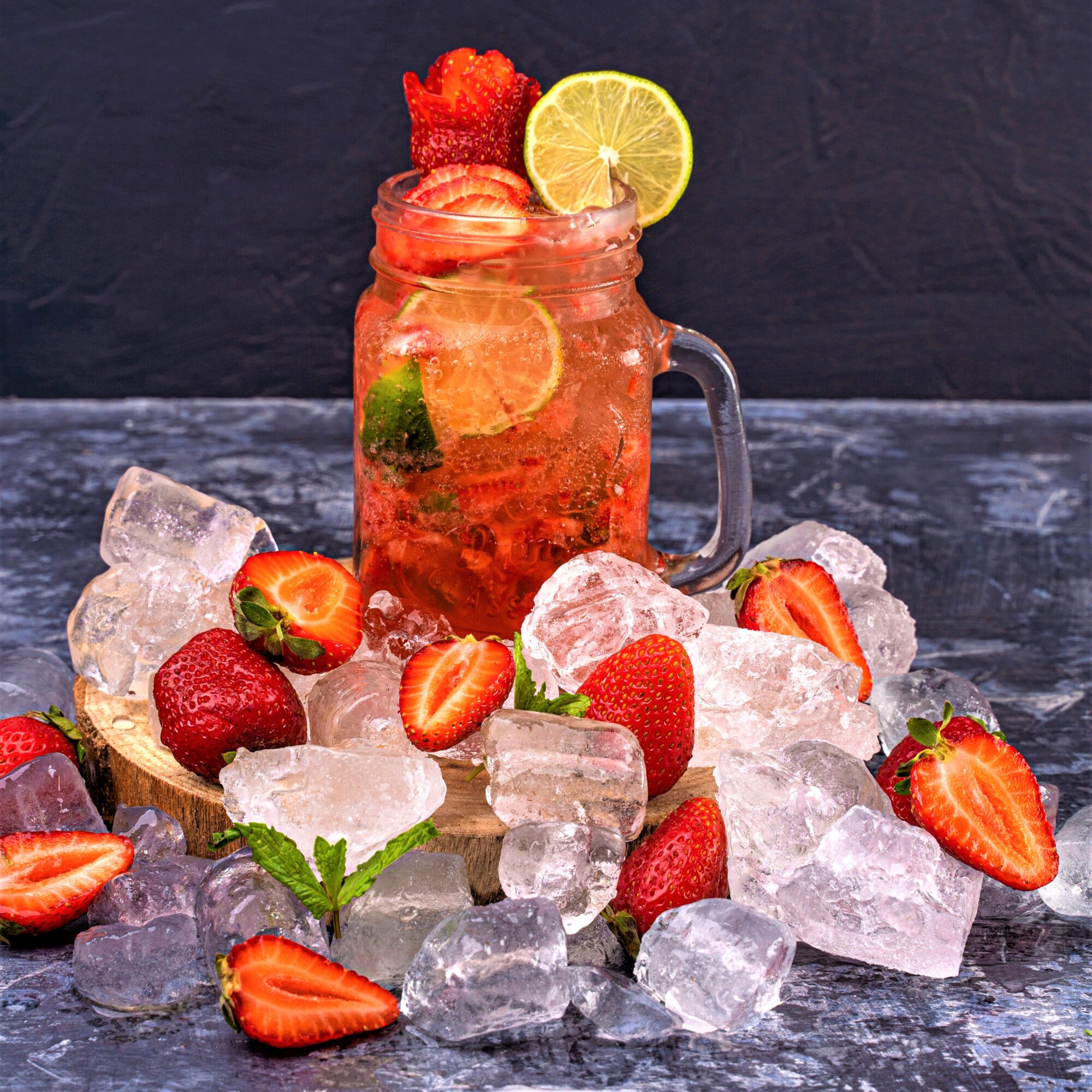 Glass of Pimms with ice and strawberries and on the surface