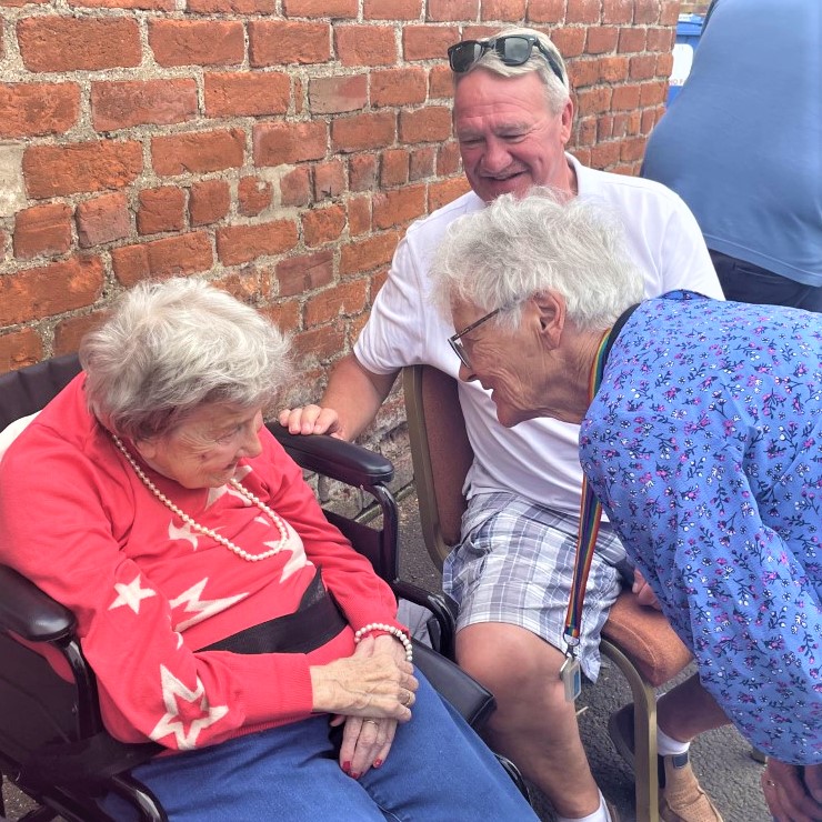 two ladies and one gentleman meeting at a community event