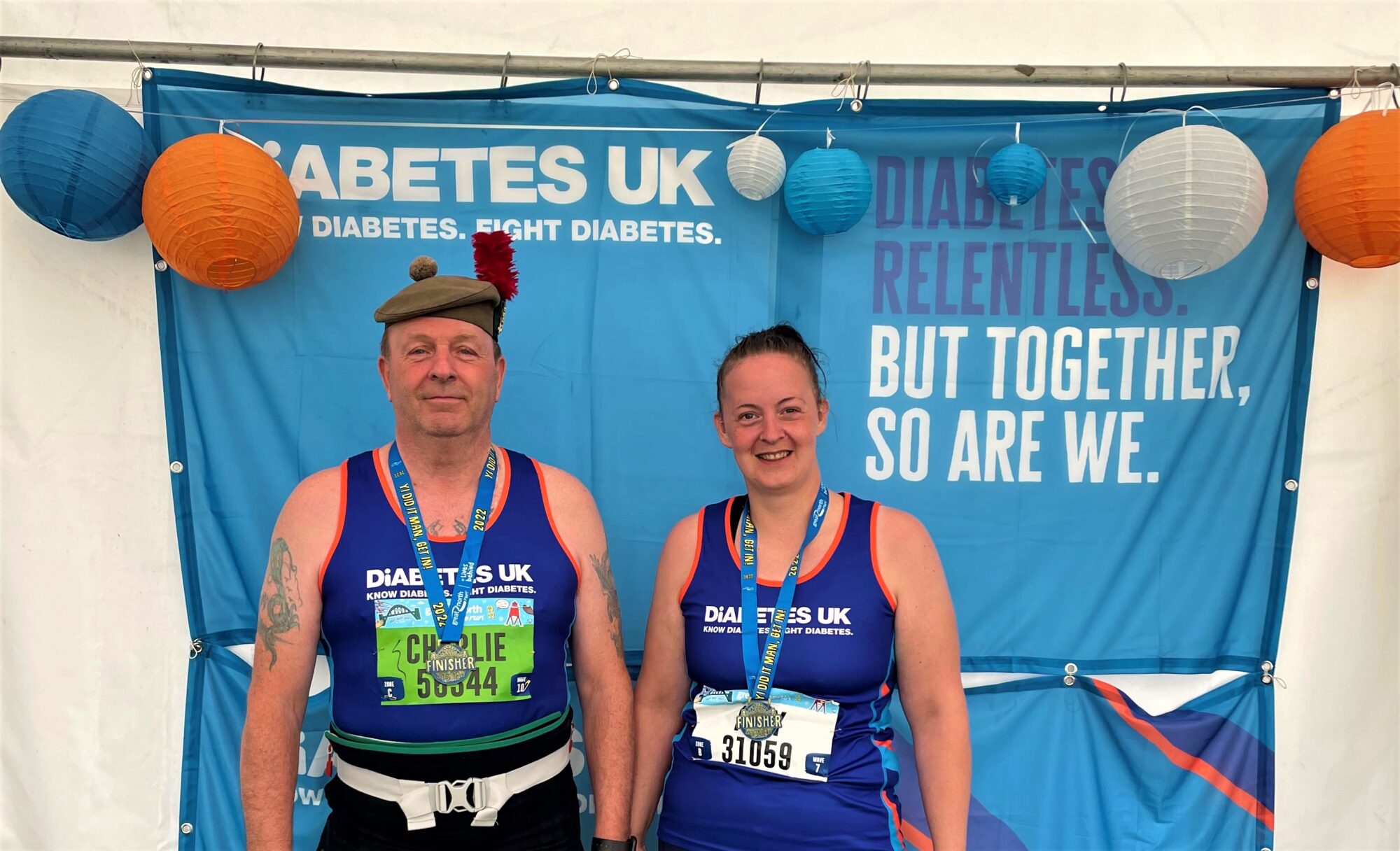 man and woman standing with medals at Great North Run banner