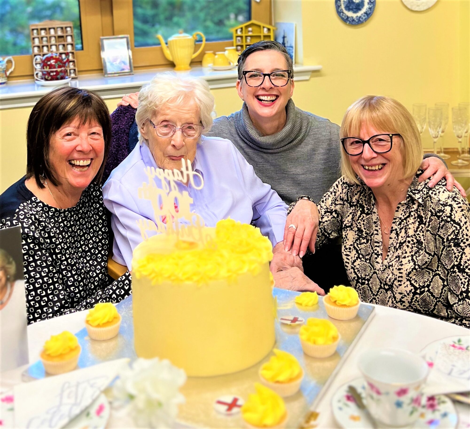 residents celebrating 100th birthday with daughters and granddaughter
