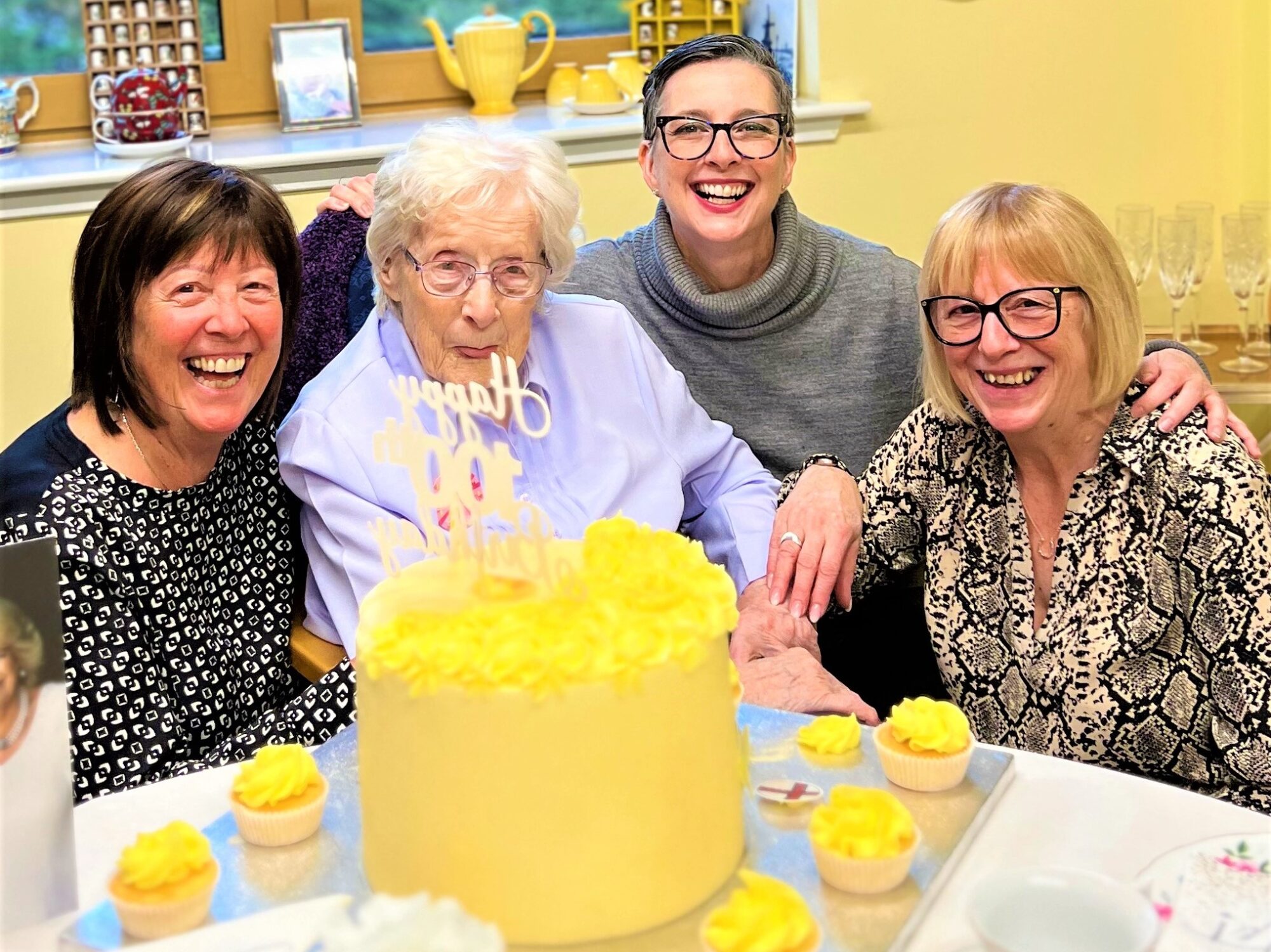 residents celebrating 100th birthday with daughters and granddaughter