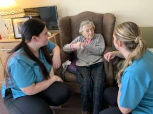 A photo of Morna and Connie Liney caring for a resident.
