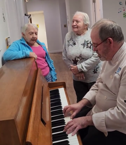 Chef accompanying Jean and Betty at Stormont Lodge on the piano.