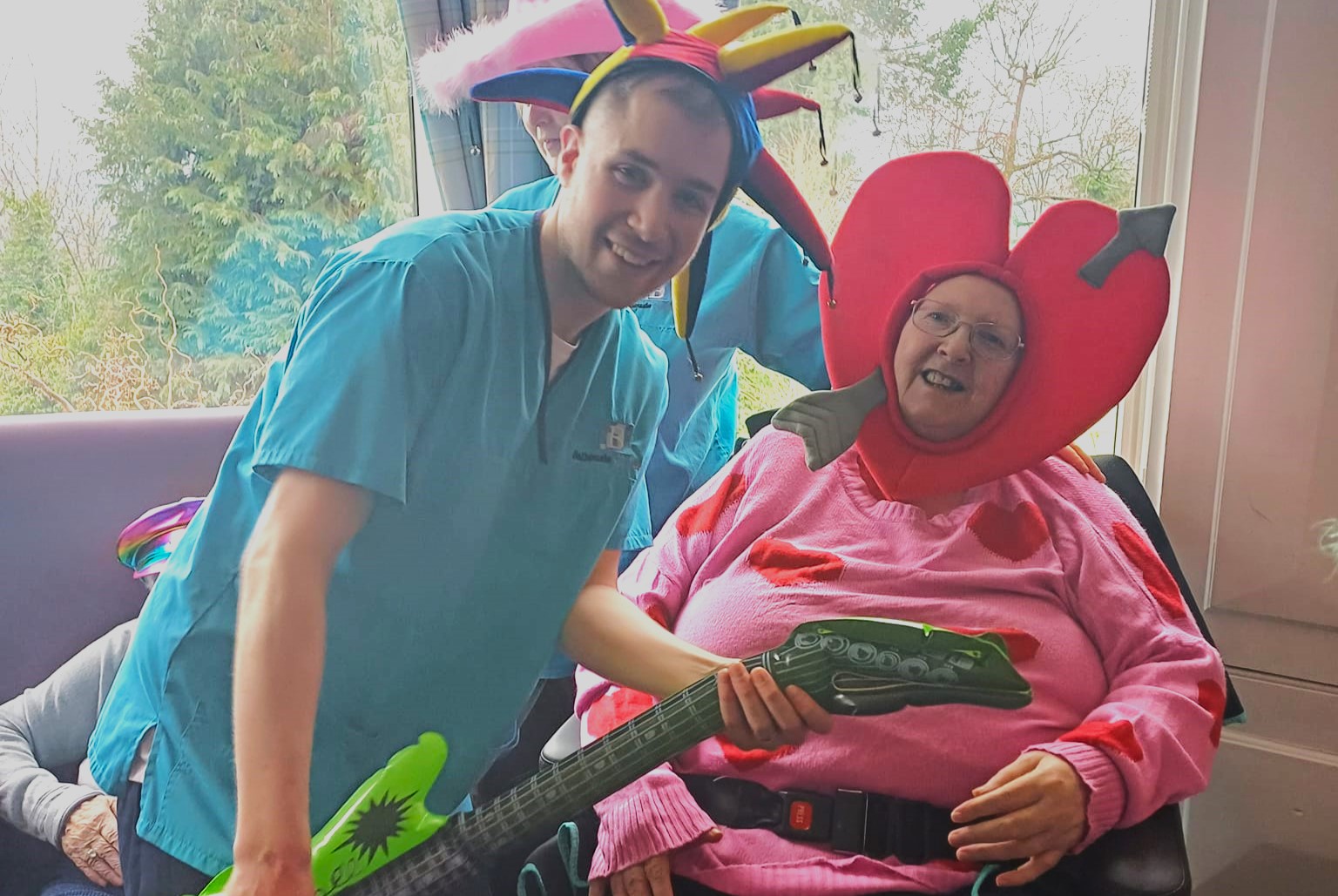 CArer with blow up guitar and resident with Heart hat